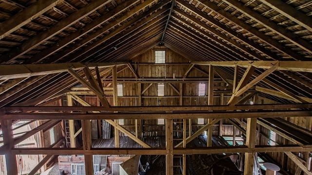 Interior of a historic timber-framed barn showing exposed roof trusses